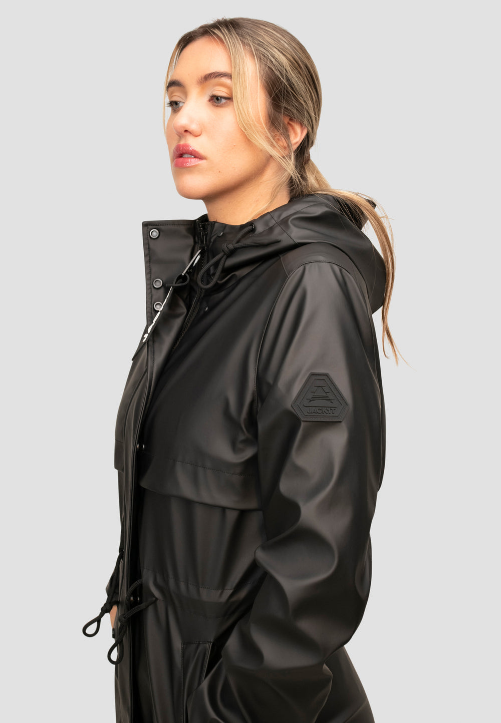 Model wearing a women's black raincoat with a hood, showcasing its stylish design and functionality.