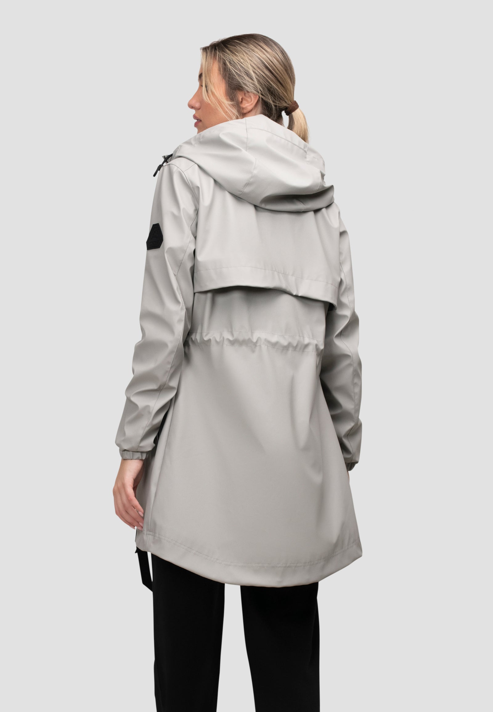 Back view of a lightweight women's grey raincoat with cape design in dusty light grey, perfect for unpredictable weather.