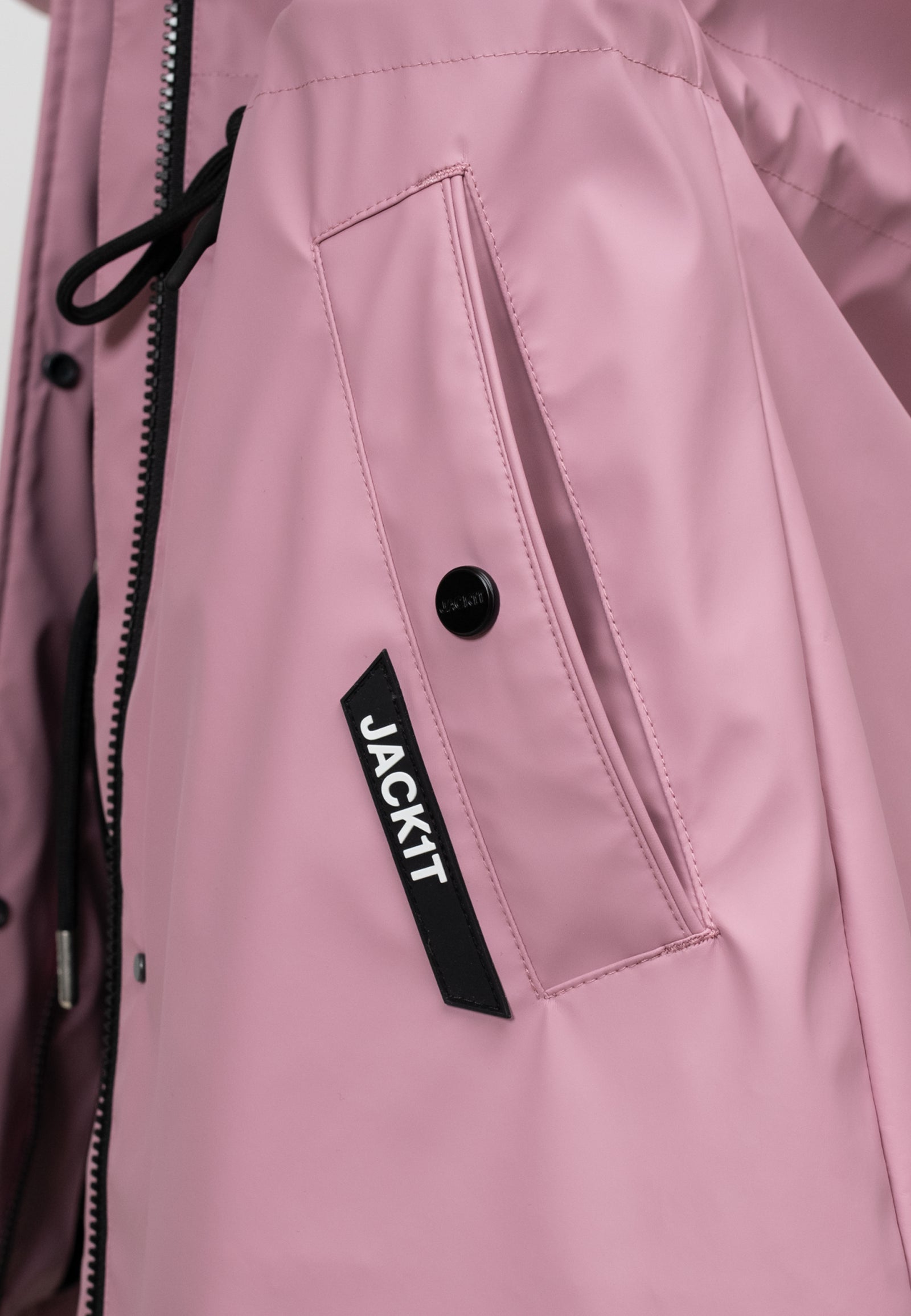 Close-up of women's pink raincoat showing pocket detail and logo, lightweight and stylish design for spring weather.