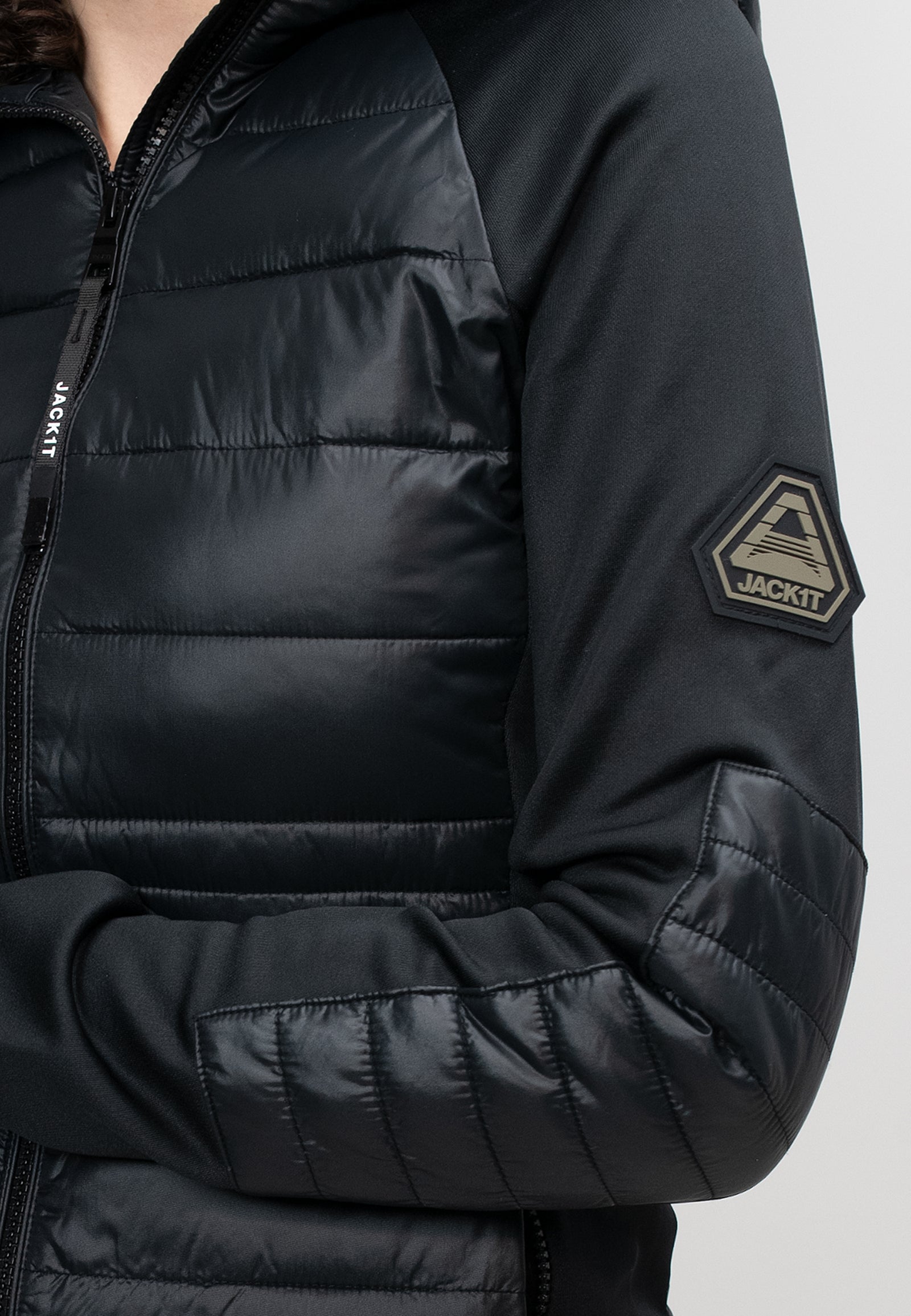 A close-up of a women's black hooded jacket showcasing the textured fabric and logo detail on the sleeve.