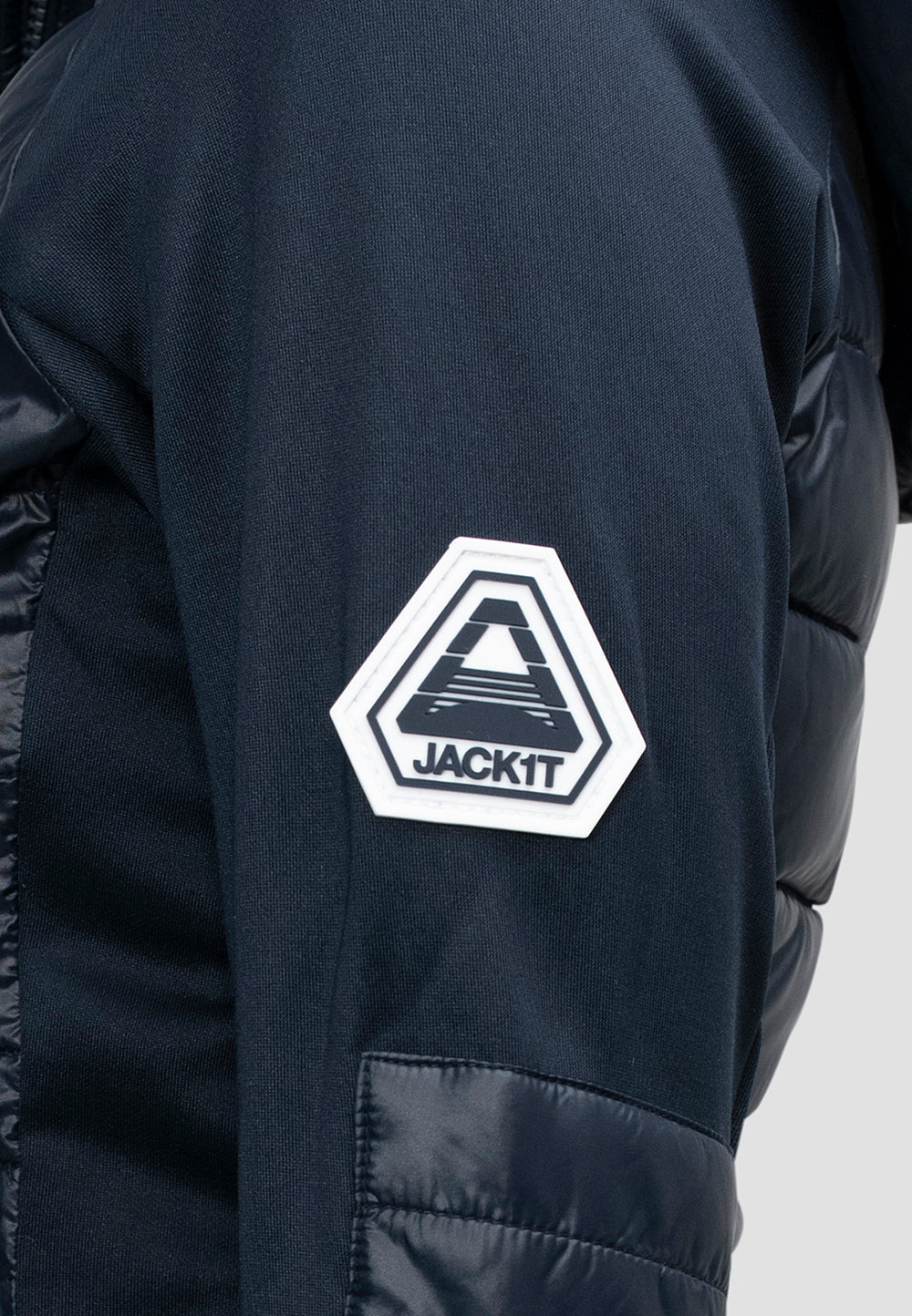 Close-up of the logo on the sleeve of a women's navy hooded jacket, showcasing the JACKIT branding.