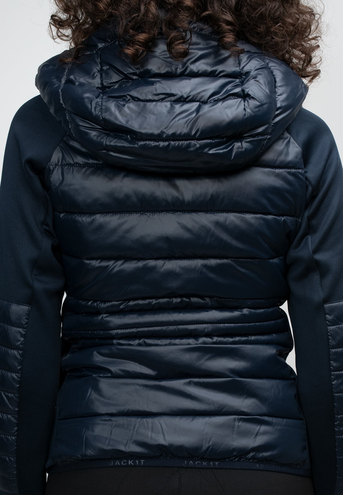 Back view of women's navy hooded jacket showcasing lightweight water-resistant fabric and hood details.