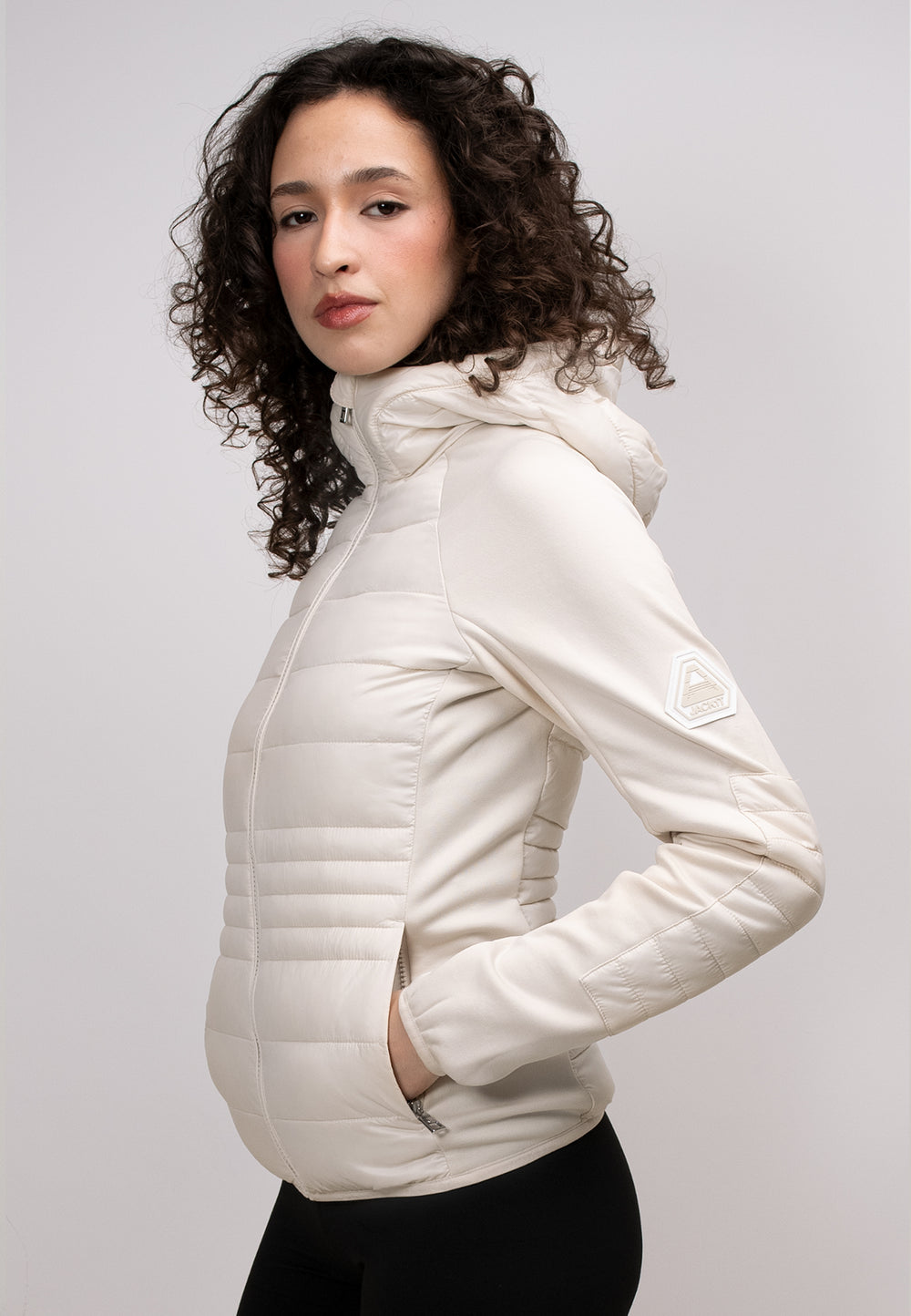 Model wearing a women's cream hooded jacket with a zippered hood and stylish design.