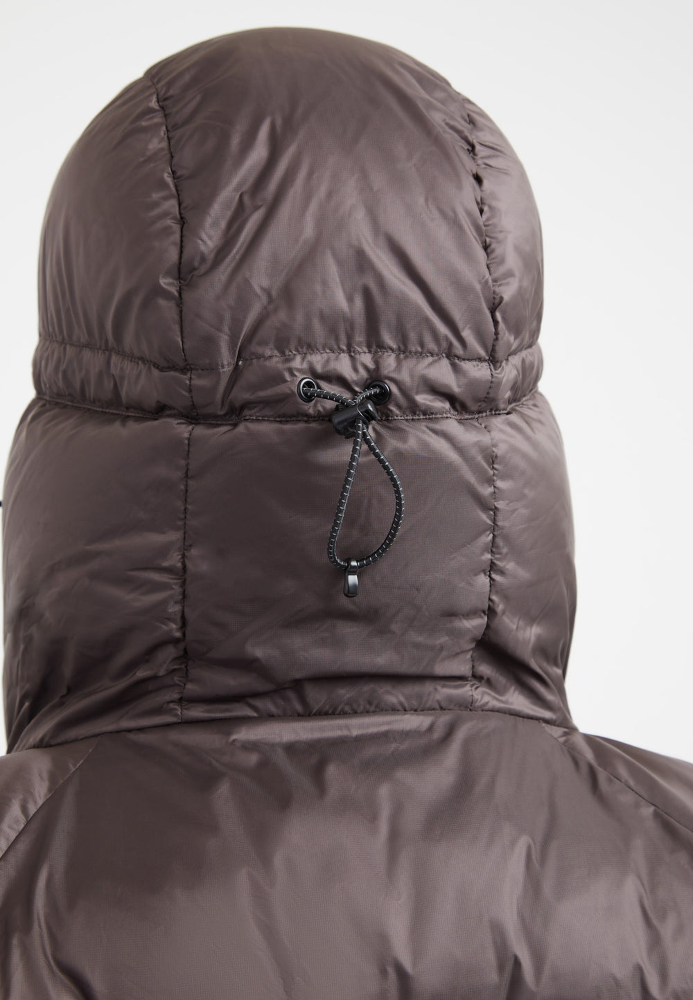 Back view of oversized puffer brown jacket with adjustable hood and durable fabric.