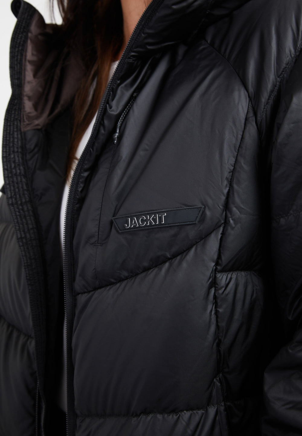 Close-up of oversized puffer black jacket featuring RDS Certified Down fill and adjustable hood.