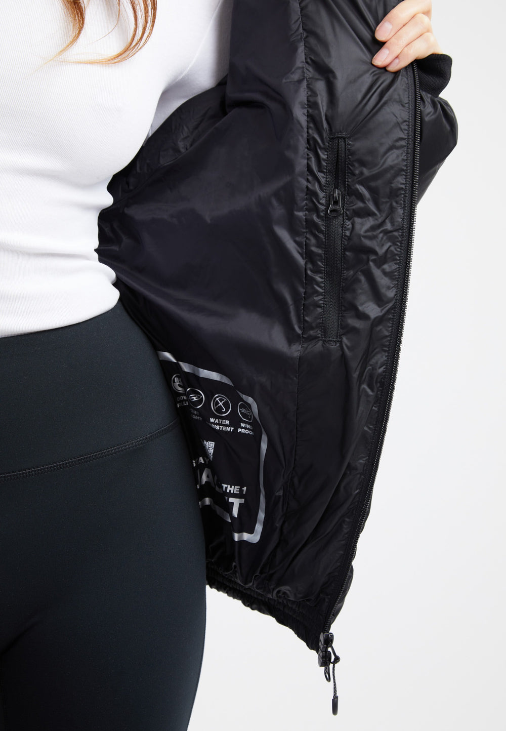 Inside view of an oversized puffer black jacket showcasing the sleek fabric and detailing.