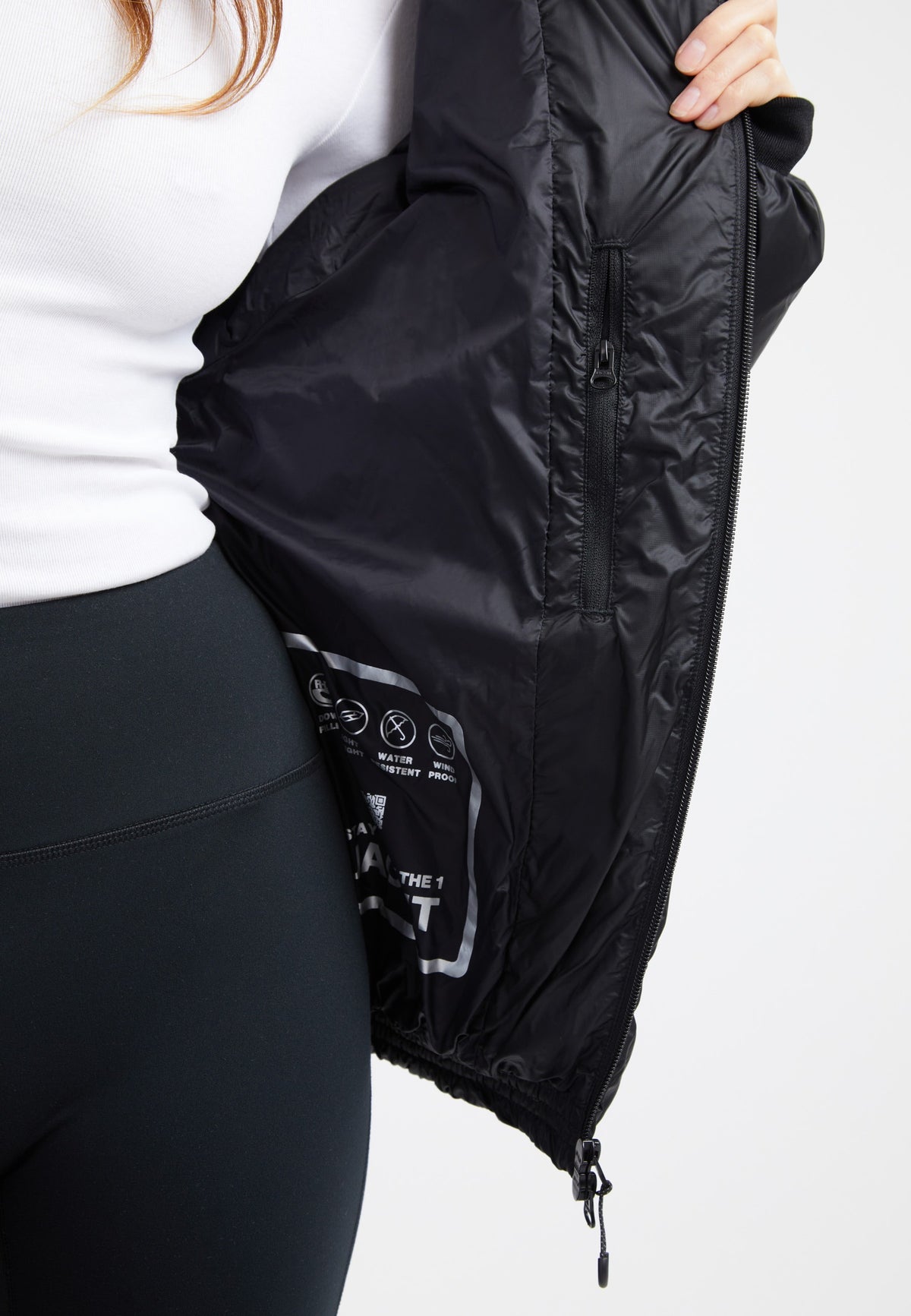 Inside view of an oversized puffer black jacket showcasing the sleek fabric and detailing.
