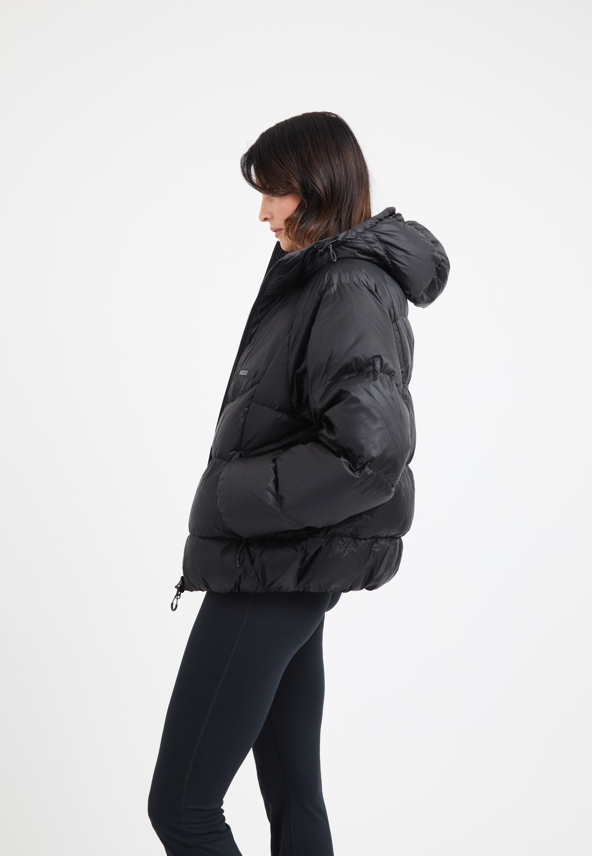 Model wearing an oversized puffer black jacket with a hood, showcasing its stylish design and features.