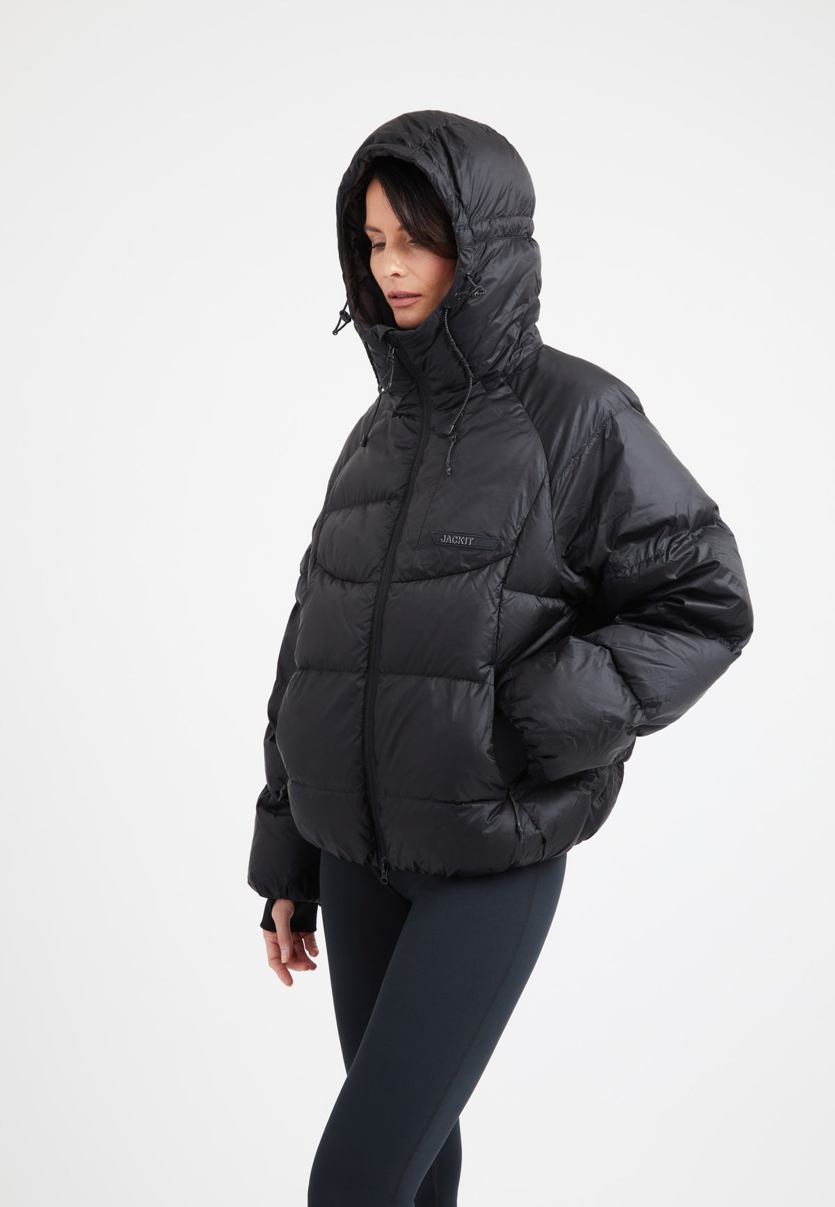 Model wearing an oversized puffer black jacket with a hood and durable fabric for warmth and style.