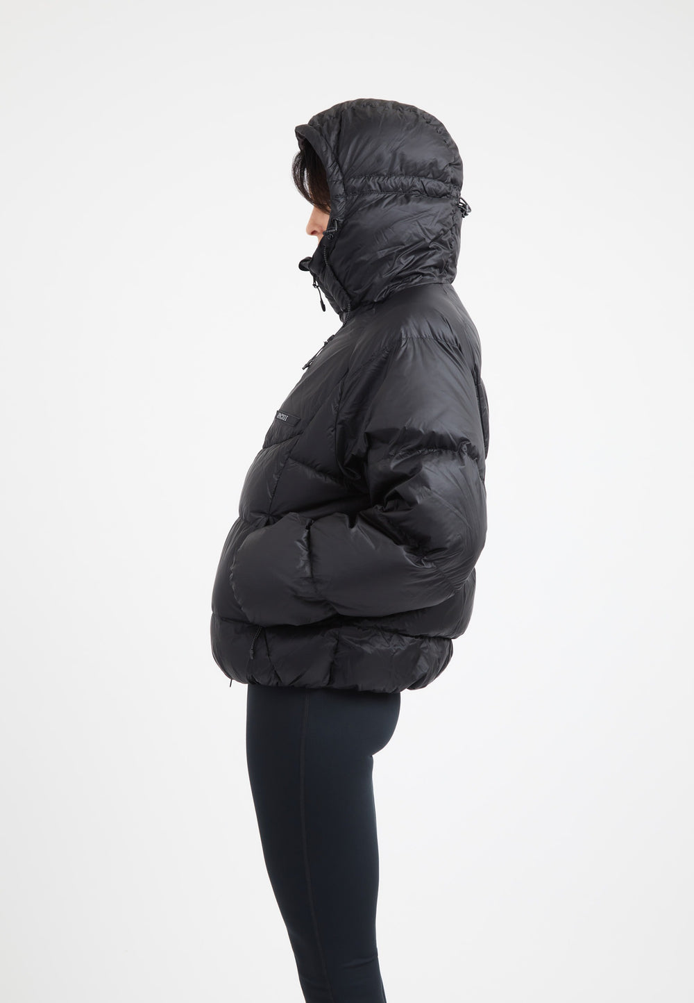 Model wearing an oversized puffer black jacket with an adjustable hood and fleece lined pockets.