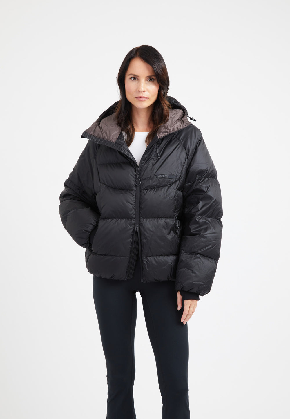 Model wearing oversized puffer black jacket with hood, showcasing its modern silhouette and durable fabric.