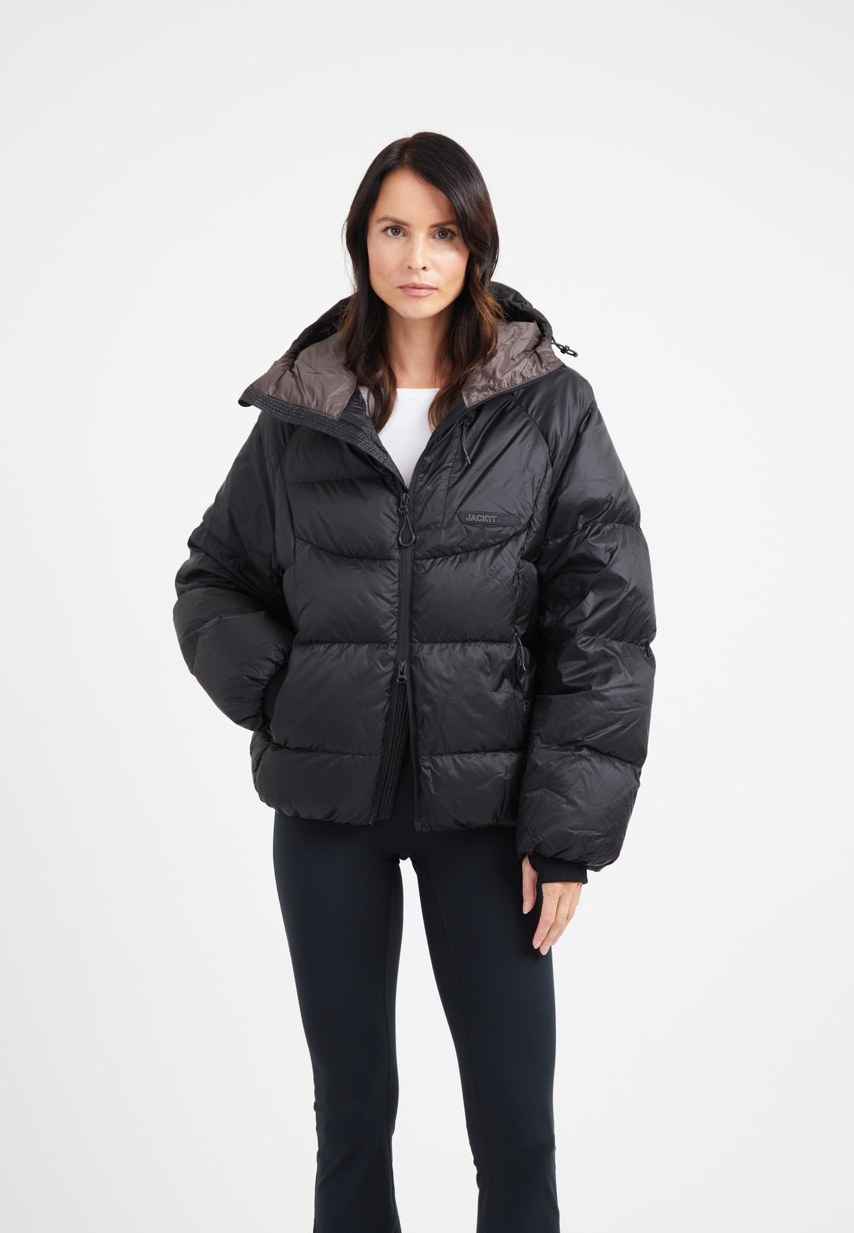 Model wearing oversized puffer black jacket with hood, showcasing its modern silhouette and durable fabric.