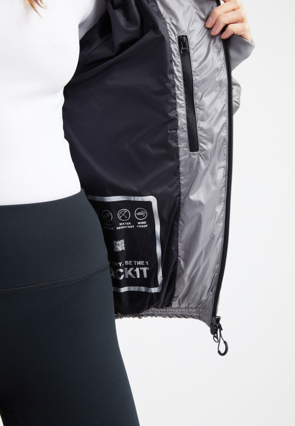 Inside view of oversized puffer grey jacket showcasing its tag and interior design details.