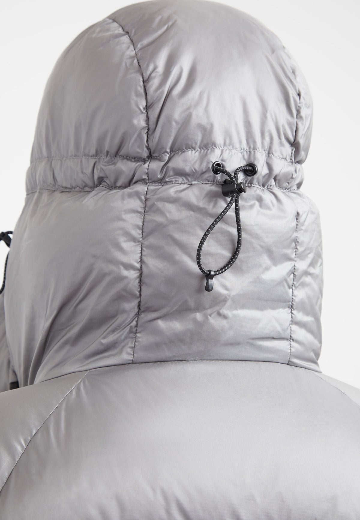 Close-up of the adjustable hood on an oversized puffer grey jacket showcasing high-quality material.