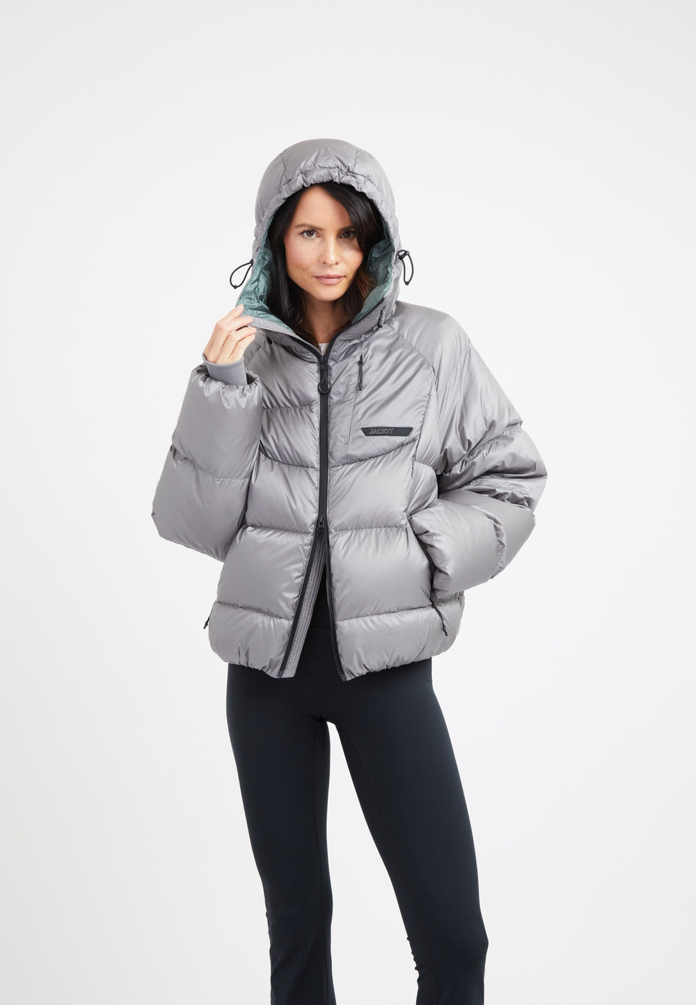 A model wearing an oversized puffer grey jacket, showcasing its stylish design and adjustable hood.