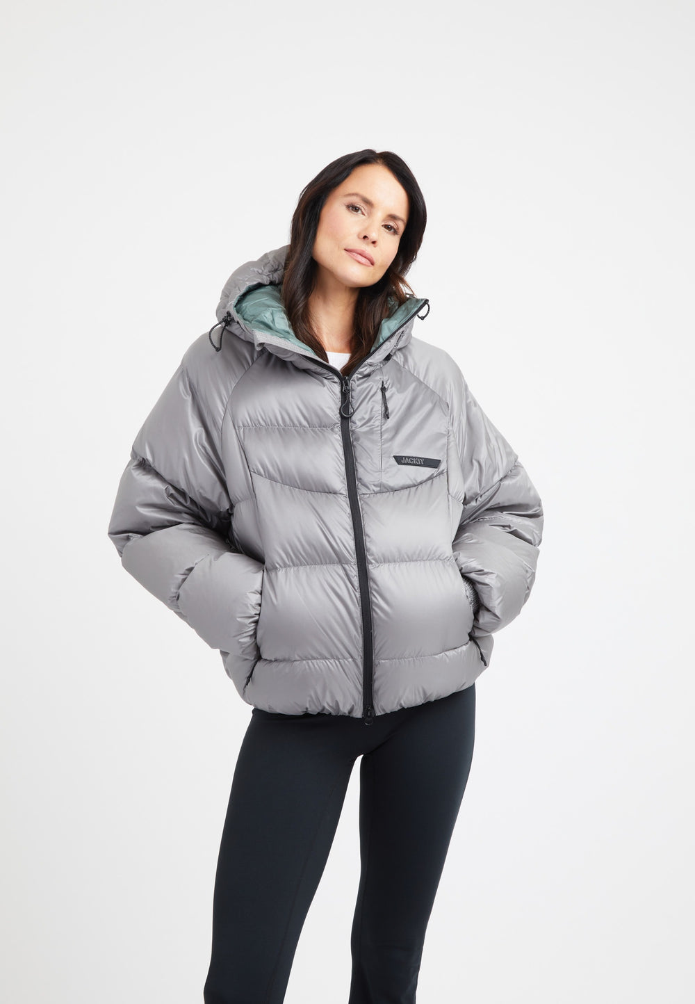 Model wearing an oversized puffer grey jacket with hood and fleece lining, showcasing modern style and comfort.