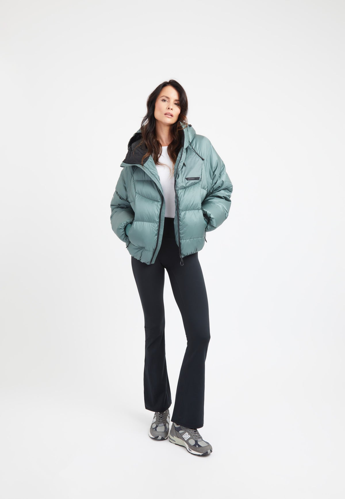 Model wearing an oversized puffer green bubble jacket with adjustable hood and fleece lined pockets.