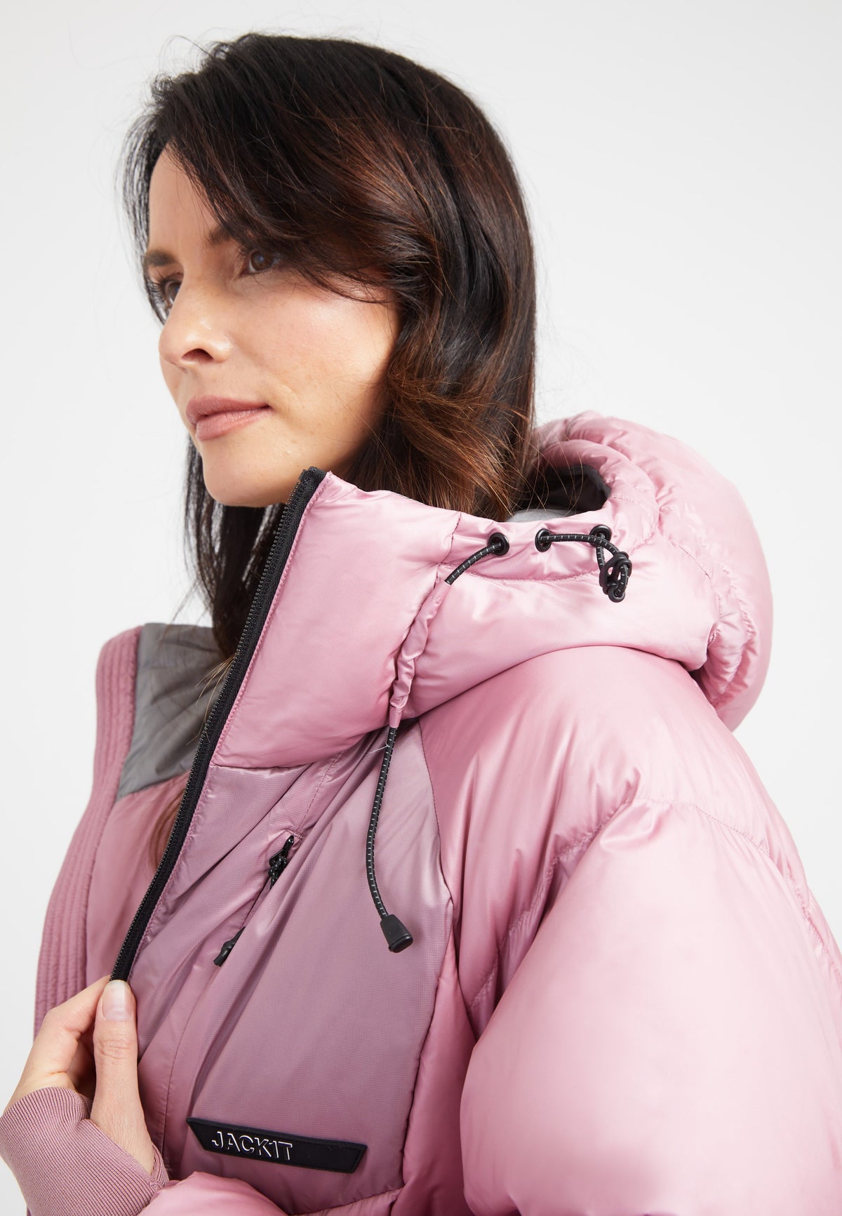 Model wearing an oversized puffer bubble jacket in pink with an adjustable hood and fleece-lined pockets.