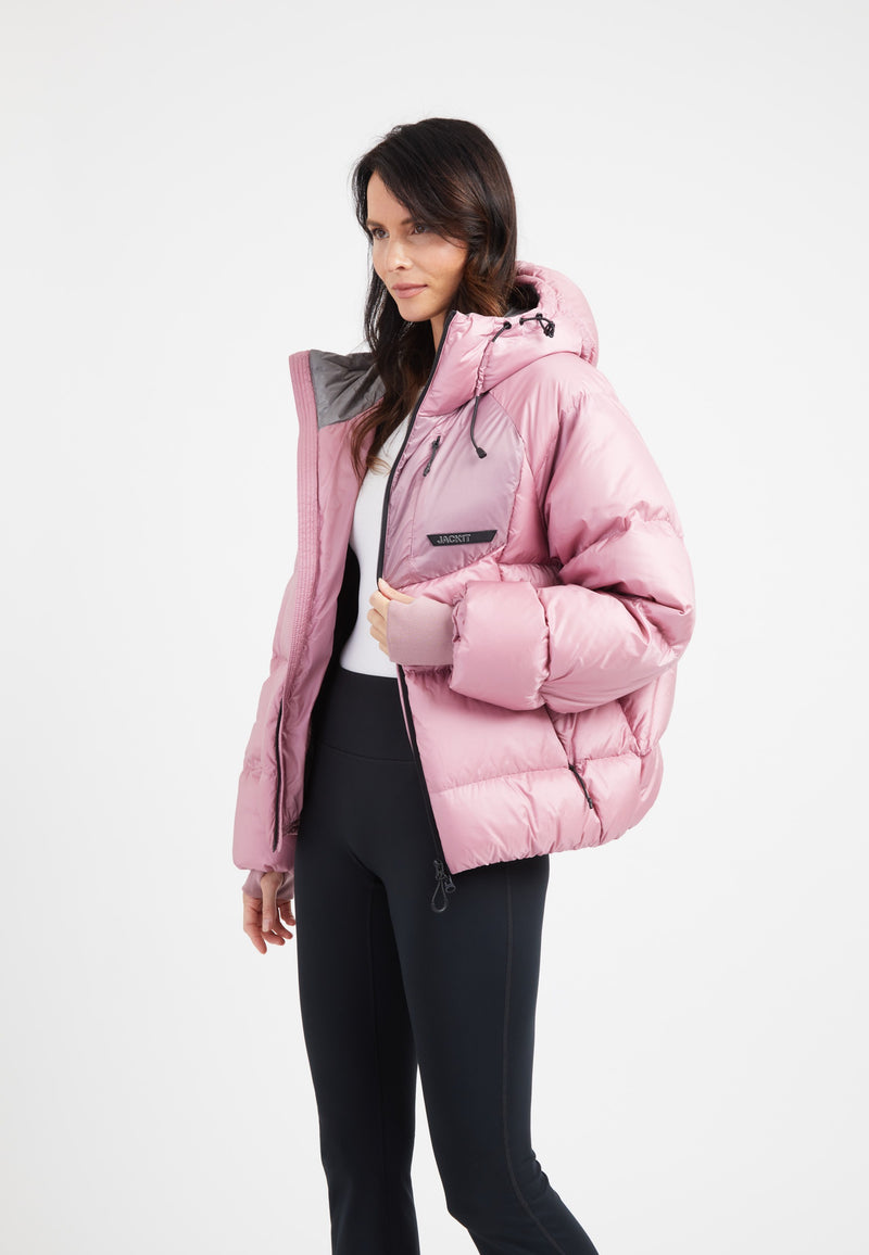 Model wearing a Bubble Jacket Pink, featuring an oversized puffer style with an adjustable hood and fleece lined pockets.