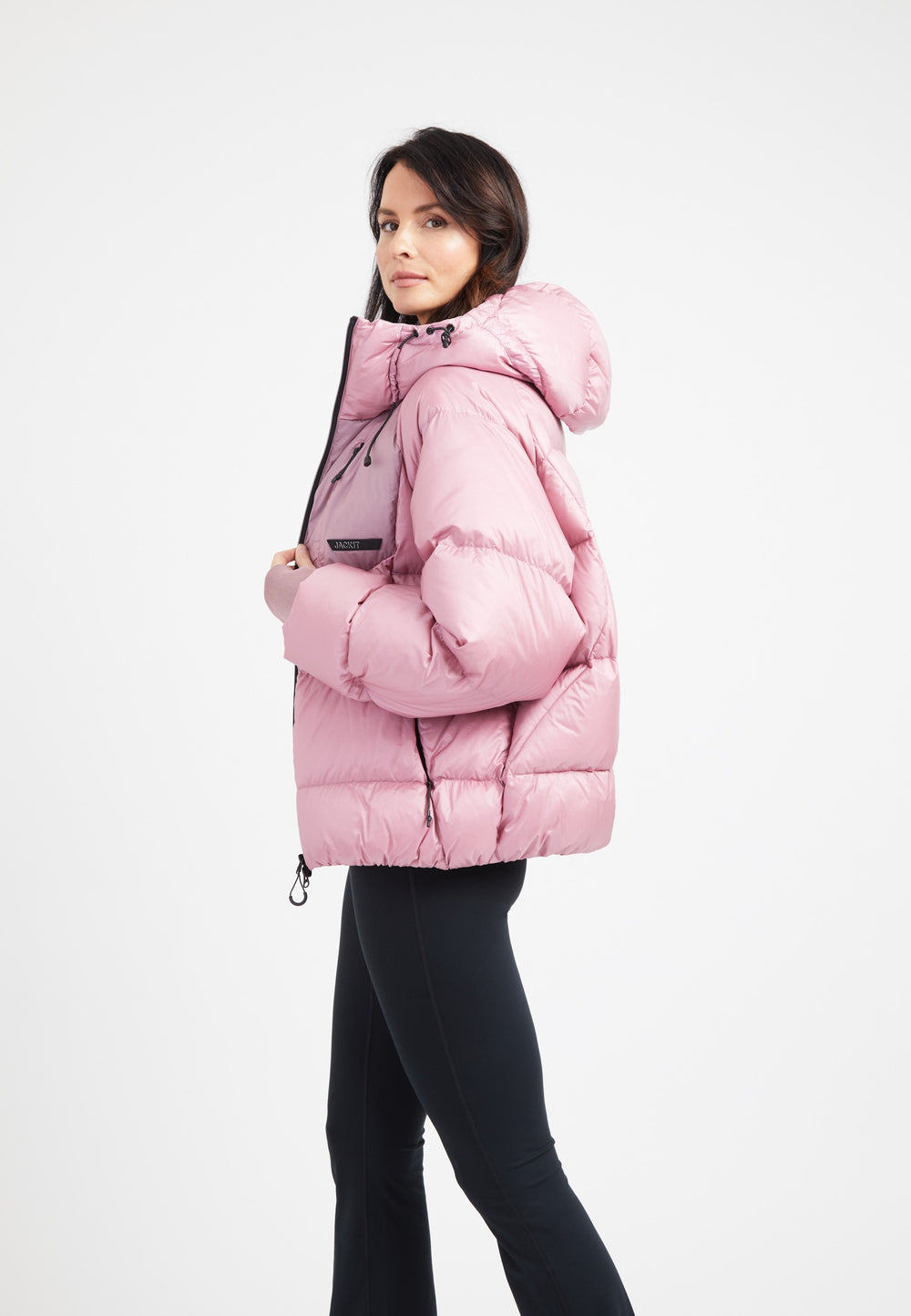 Model wearing an oversized puffer pink jacket with an adjustable hood and fleece lined pockets.