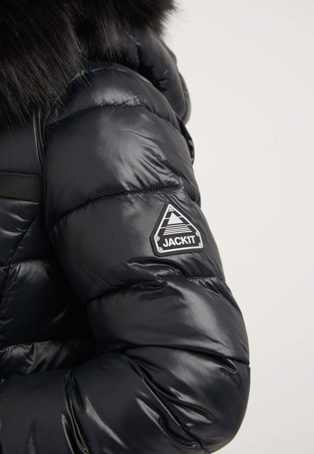 Close-up of R4D Tricolore Racer Jacket Black showing a reflective badge on the sleeve. Ideal black womens puffer jacket.
