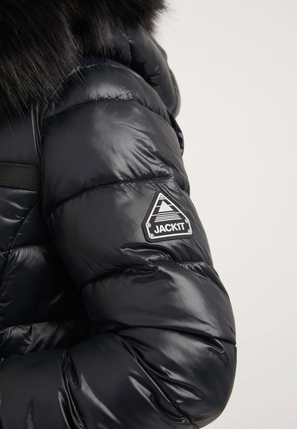 Close-up of R4D Tricolore Racer Jacket Black showing a reflective badge on the sleeve. Ideal black womens puffer jacket.