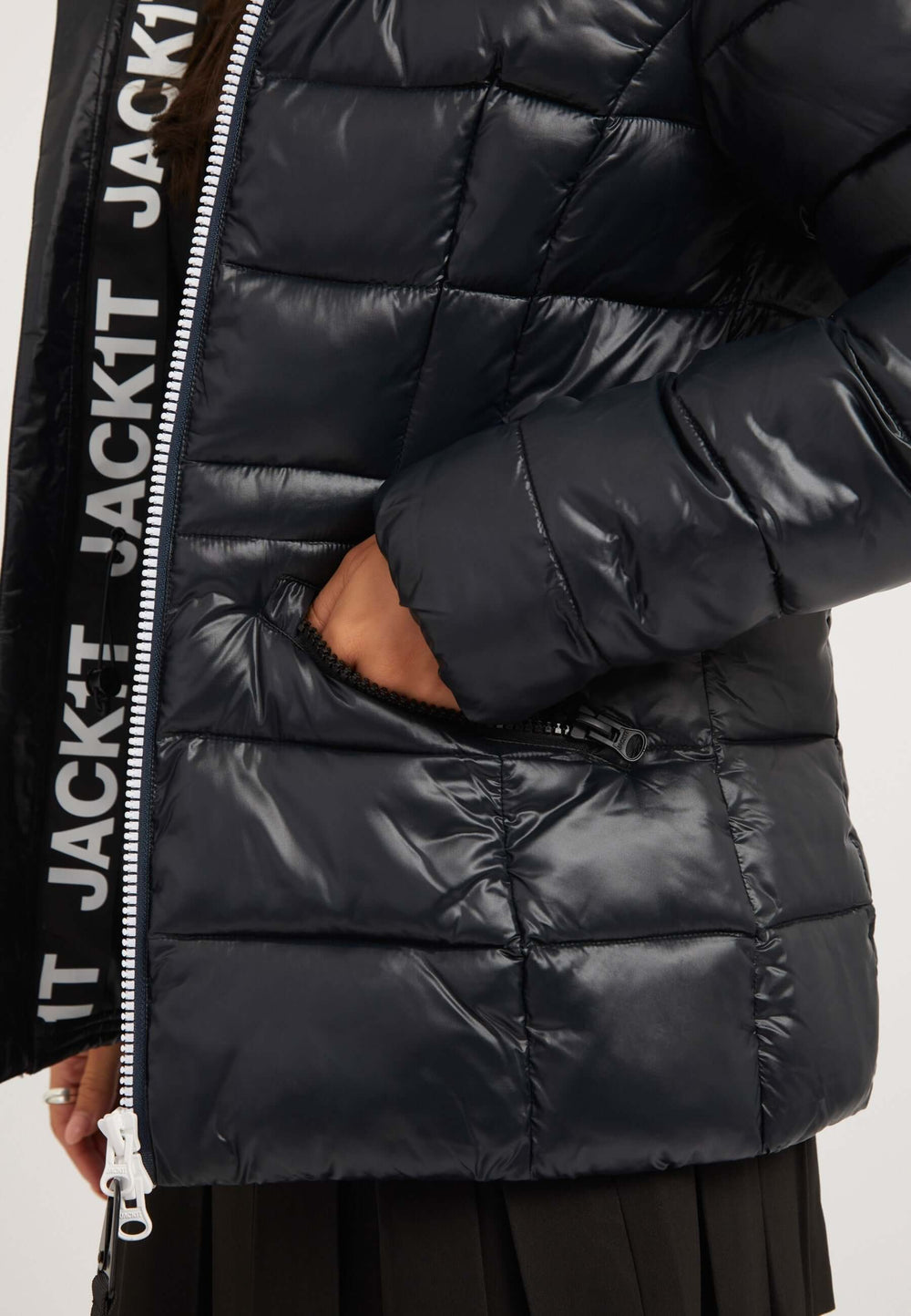 Close-up of black womens puffer jacket showing tapered racer fit and pocket detail.