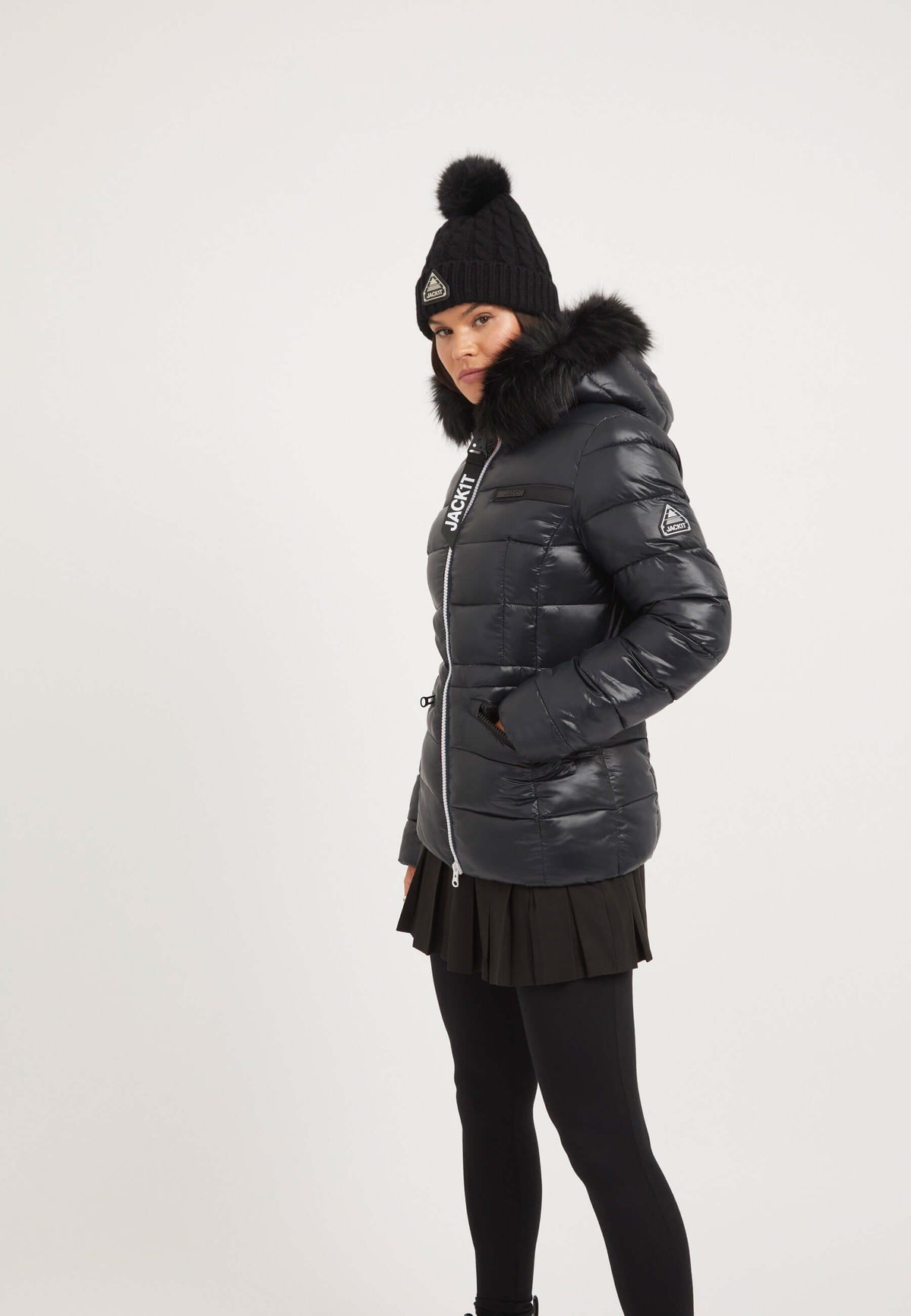 Model wearing a stylish black womens puffer jacket with faux-fur trim and zipped pockets.